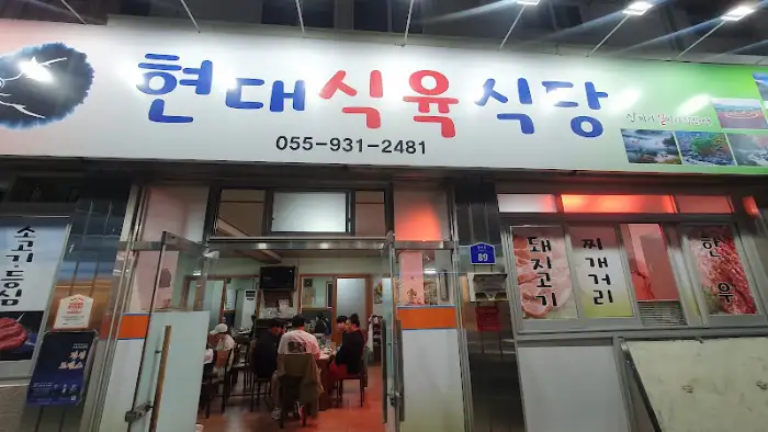 현대식육식당의 간판과 전면 모습, 손님들이 식사 중인 내부 일부