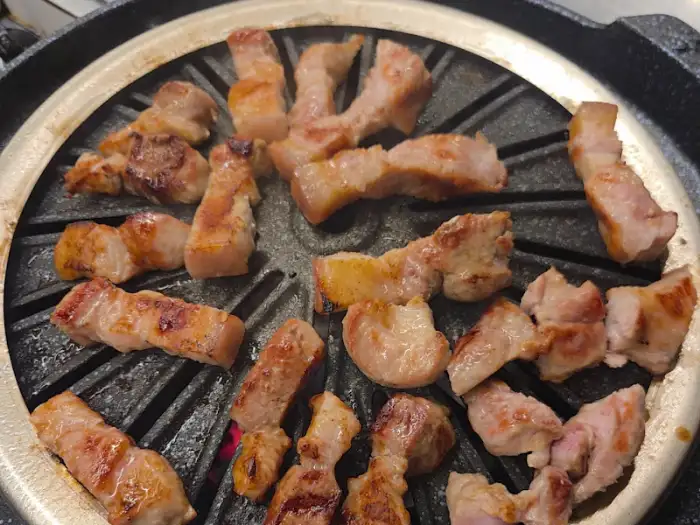 몽실식당의 불판 위에서 익어가고 있는 흑돼지 삼겹살
