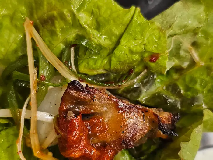 상추와 깻잎 위에 얹어진 몽실식당의 흑돼지 구이와 쌈무