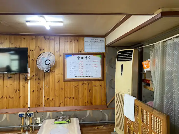 물레식당 내부 모습, 나무 벽과 선풍기, 에어컨이 보입니다.