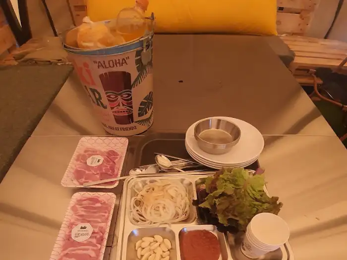 무수아취 캠핑장의 테이블 세팅 모습: 신선한 고기, 채소, 양파 슬라이스
