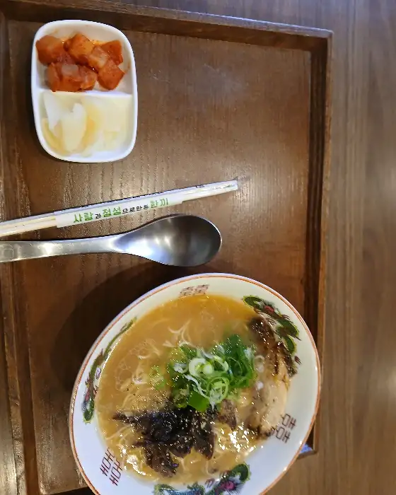 나무 쟁반 위에 놓인 라멘 그릇과 젓가락, 깍두기