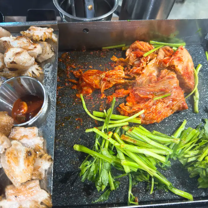 금돈집 광명하안점에서 삼겹살과 함께 구워지는 김치와 미나리