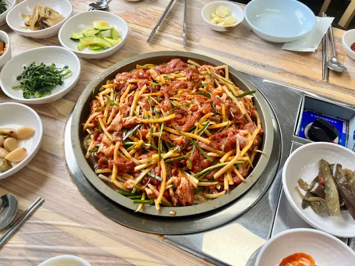 산성가든 오리불고기를 쌈 채소에 싸서 먹는 모습