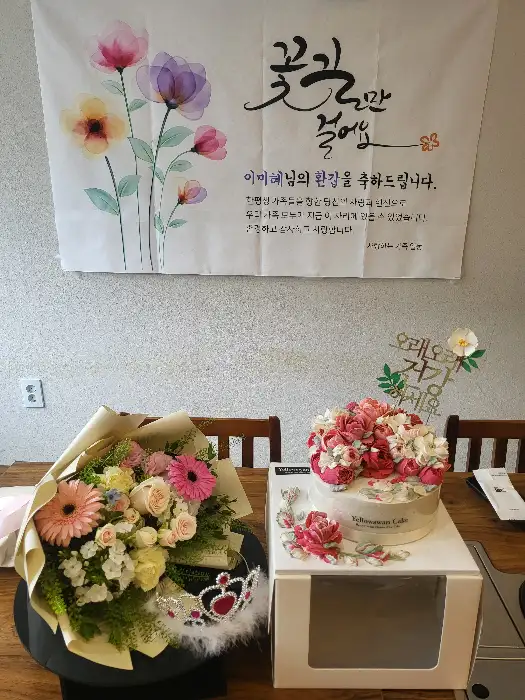 옐로우스완케이크의 케이크와 꽃다발이 함께 놓여있는 모습