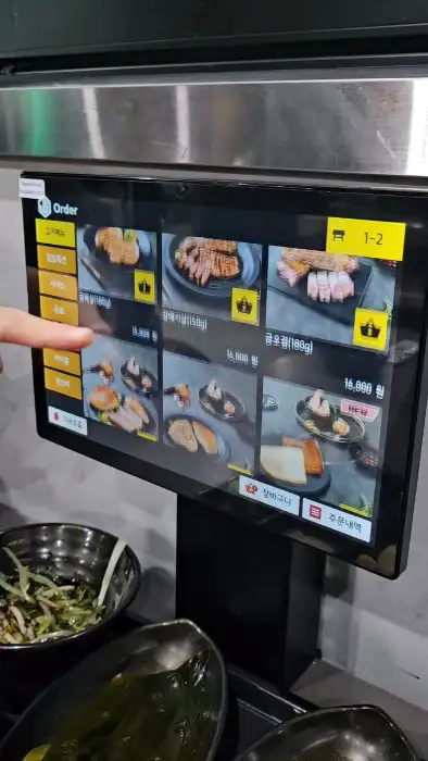 금돈집 광명하안점의 메뉴판이 터치스크린으로 제공되고 있는 모습