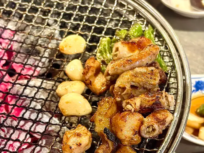 숯불 위에서 맛있게 익어가는 백호양대창 이수점의 곱창과 마늘