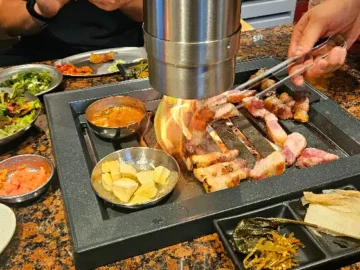 돝돝 매장에서 직접 구워지는 두툼한 삼겹살과 곁들임 반찬들