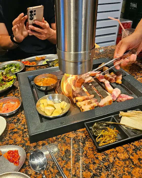 돝돝 매장에서 직접 구워지는 두툼한 삼겹살과 곁들임 반찬들