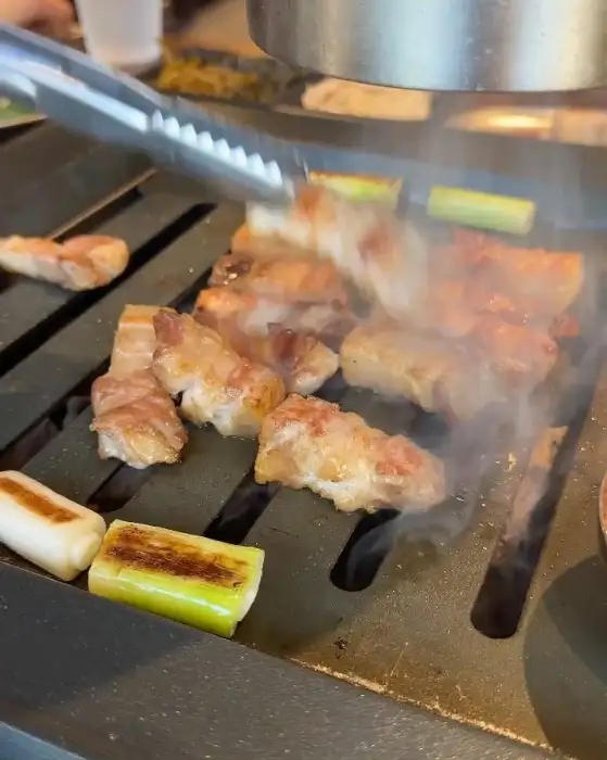 돝돝의 삼겹살이 숯불 위에서 맛있게 구워지는 모습
