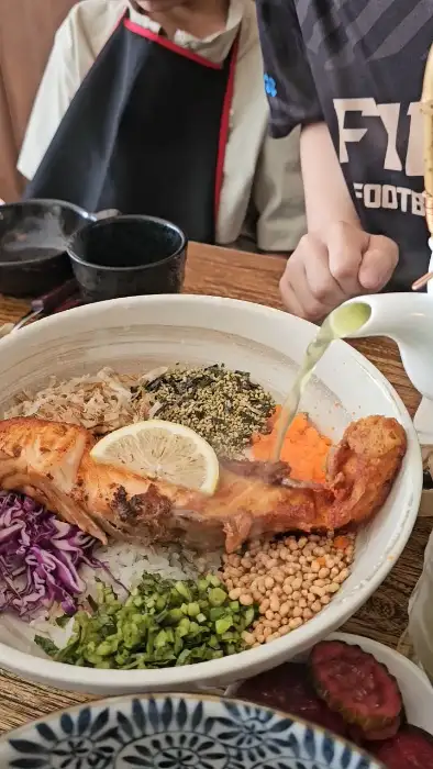 연어 오차즈케 위에 따뜻한 육수를 붓는 모습