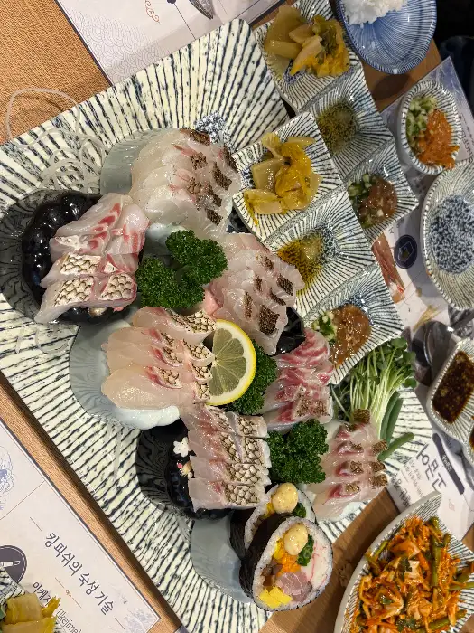 푸짐하게 차려진 모듬회 한 상차림에 신선한 해산물과 곁들임이 돋보입니다.
