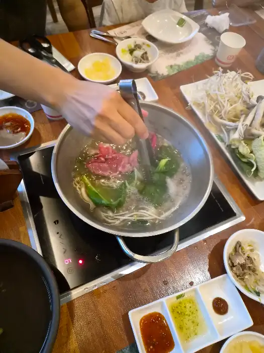샤브샤브 육수에 다양한 채소와 고기를 넣는 모습