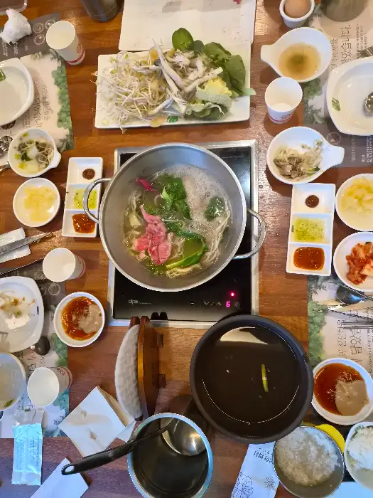 테이블 위 먹음직스러운 샤브샤브 육수와 재료들