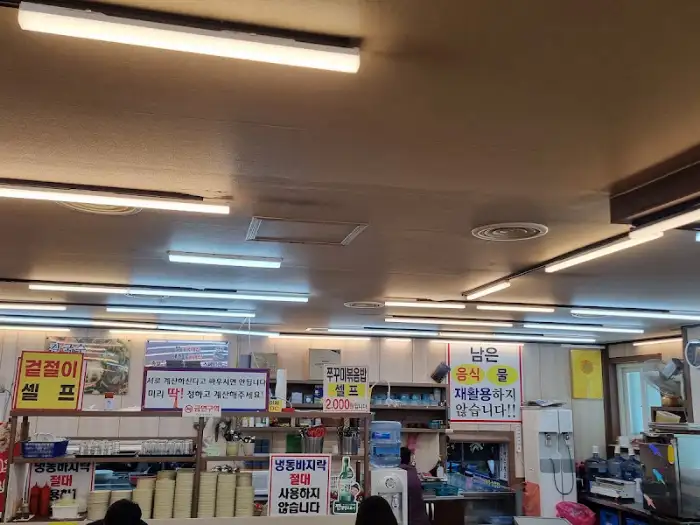 가게 내부 선반에 정갈하게 쌓여 있는 그릇들과 각종 소스, 양념통들이 보이는 모습