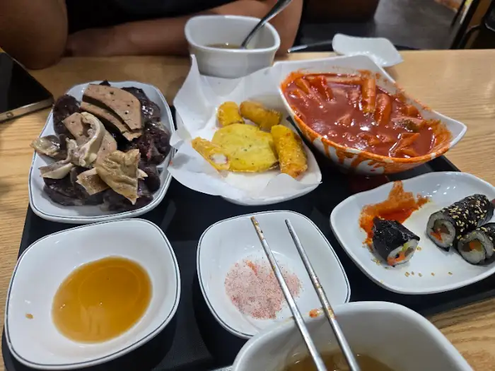 쪼매매운떡볶이 테이블에 차려진 푸짐한 떡볶이와 곁들임 메뉴들