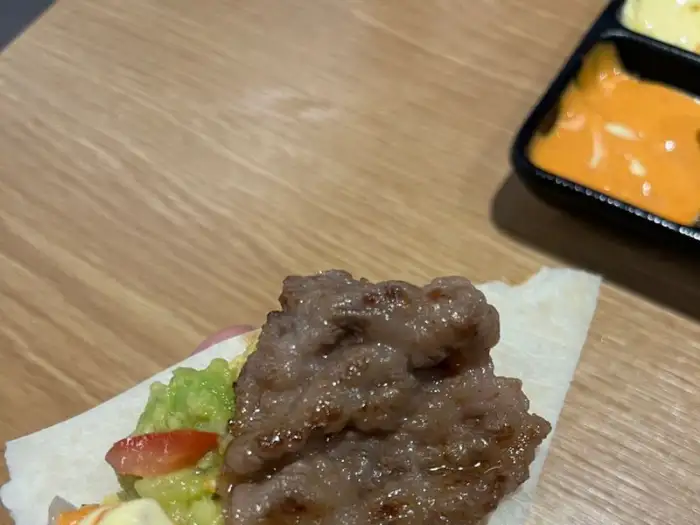 또띠아에 올린 고기와 아보카도, 토마토, 소스가 어우러진 타코