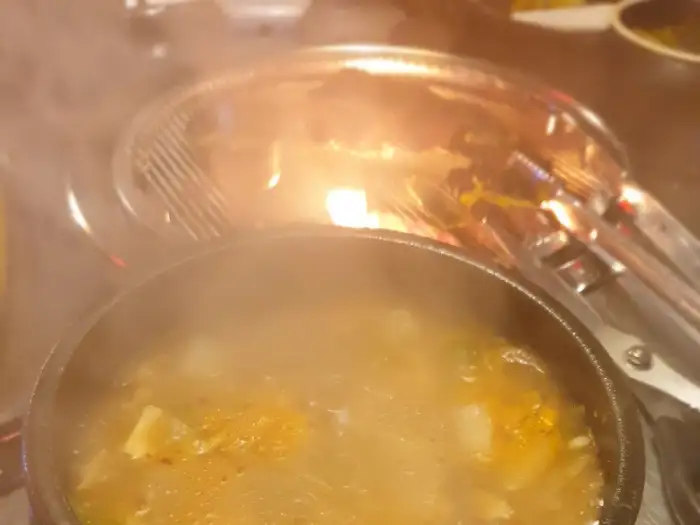 태백실비식당의 불판 위에서 구워지는 소고기와 된장찌개
