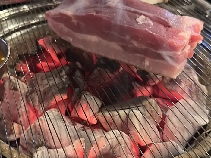 식껍 용산점 숯불 위 두툼한 삼겹살 덩어리
