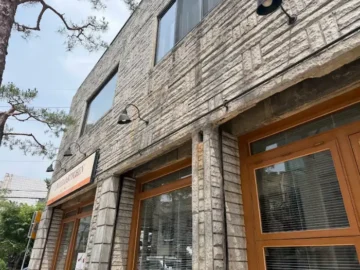 운멜로키친 3호점의 돌 외벽과 나무 창문이 돋보이는 외부 모습