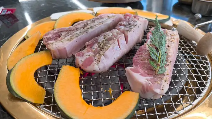 숯불 위에서 구워지는 신선한 흑돼지와 단호박의 먹음직스러운 모습