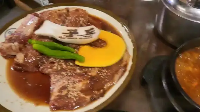 양념된 돼지갈비와 곁들임 채소가 함께 담긴 접시