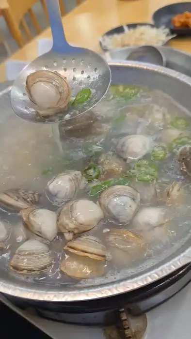 국자로 조개를 건져 올리는 모습