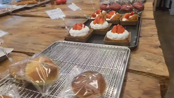 딸기 생크림이 올라간 타르트와 컵케이크가 진열되어 있다.