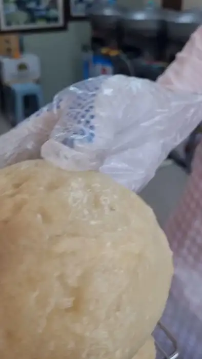 투명한 비닐장갑을 낀 손이 술빵의 겉면을 만져보고 있습니다.