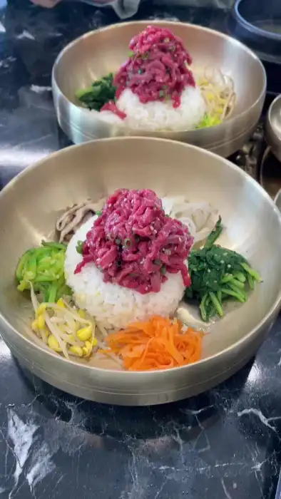 정갈하게 차려진 육회비빔밥은 신선한 육회와 다채로운 채소가 조화로운 메뉴
