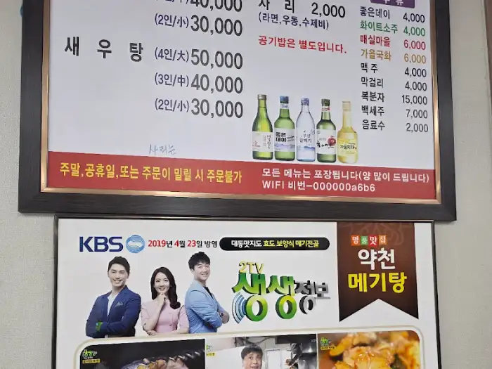 약천메기탕 메뉴판과 술병들이 진열된 모습