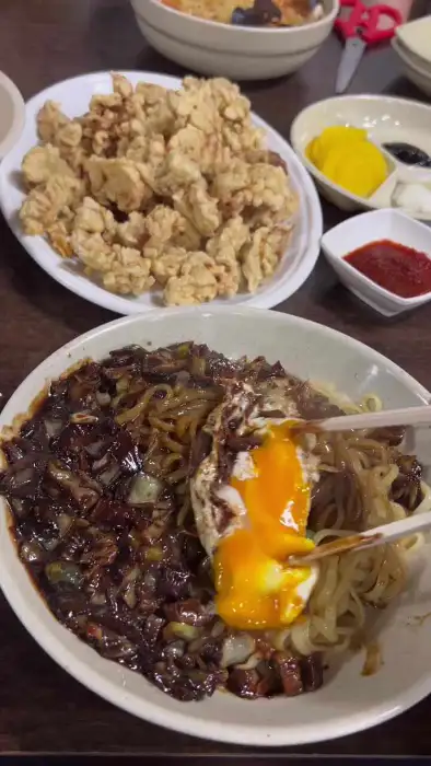 간짜장 면에 계란 노른자를 비비는 모습