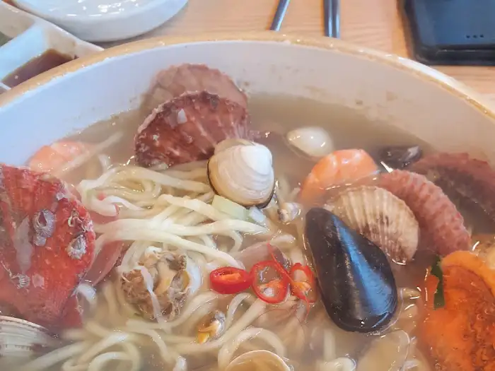 해물칼국수 그릇 속의 풍성한 해산물과 면발