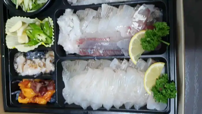 잘 손질된 광어회와 깻잎, 레몬 등이 정갈하게 담겨 있습니다.
